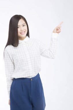 Beyaz arkaplanı işaret eden güzel Japon kadının stüdyo fotoğrafı. 