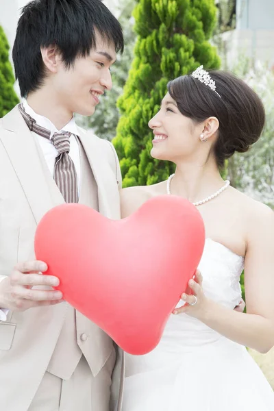 Schönes Glückliches Junges Hochzeitspaar Hält Rotes Herz Zusammen — Stockfoto