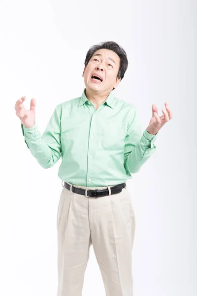 白い背景に立っている怒っている先輩アジア人男性 — ストック写真