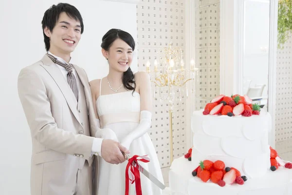 Красивая Счастливая Молодая Свадебная Пара Нарезает Праздничный Торт Вместе — стоковое фото