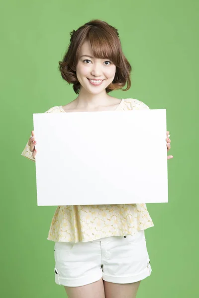 日本美女肖像 背景为绿色 手持空白卡片 — 图库照片