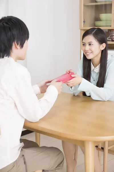 asian young woman receiving gift box from man