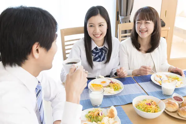 キッチンで一緒に朝食を食べる3人の日本の家族 — ストック写真