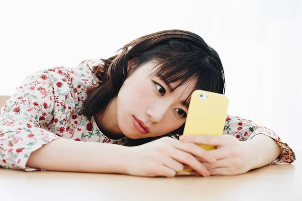 집에서 스마트폰을 사용하는 아름다운 아시아인 — 스톡 사진