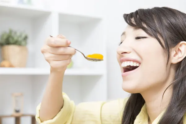 日本の若い女性が自宅でゼリーを食べる笑顔 — ストック写真