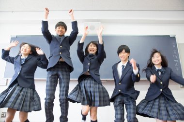 Sınıfa atlayan genç Japon öğrencilerin portresi.