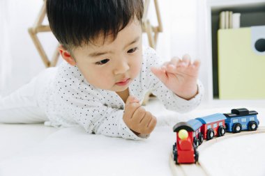 Şirin Japon çocuk evde oyuncaklarla oynuyor.