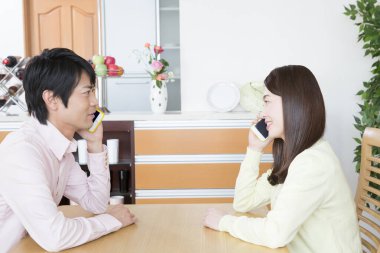 Kafede akıllı telefonları olan genç bir çift.