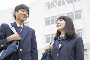 Okulda çantalı genç Japon öğrencilerin portresi.