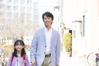 Baba ve kızı şehirde yürüyor. 