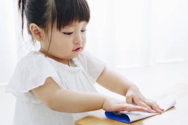 Küçük tatlı Japon kız oturma odasında oyuncaklarla oynuyor.