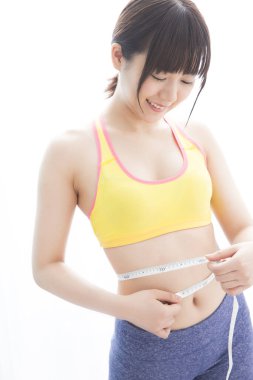 Şişman Asyalı kadın belini ölçüyor.