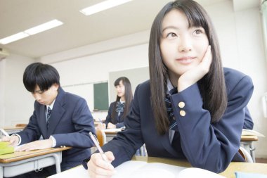 Genç Japon öğrenciler sınıfta okuyor.