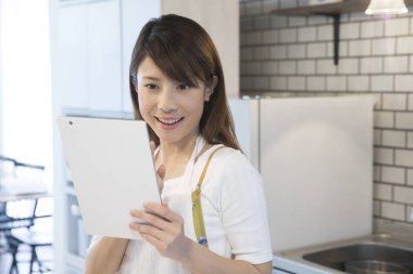 Asyalı kadın evde tablet kullanma