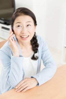 Kapat telefonu olan güzel, yaşlı Asyalı kadını.