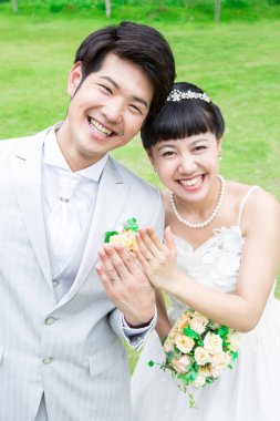 Parktaki genç Asyalı yeni evlilerin portresi.