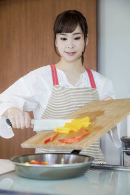 Kadın mutfakta yemek hazırlıyor, biber kızartıyor. 