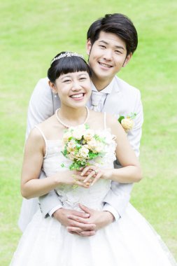 Parktaki genç Asyalı yeni evlilerin portresi.