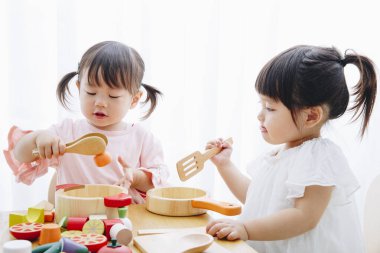 Ev içi oyuncaklarla oynayan sevimli Japon kızlarının yakın çekimleri. 