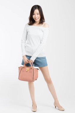 Beyaz arka planda el çantalı güzel bir Japon kadının stüdyo fotoğrafı. 