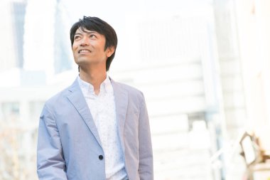 Asyalı işadamı şehirde yürüyor