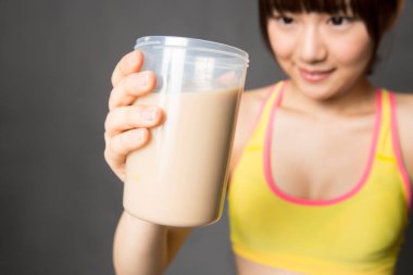 Asyalı kadın elinde içki tutuyor.