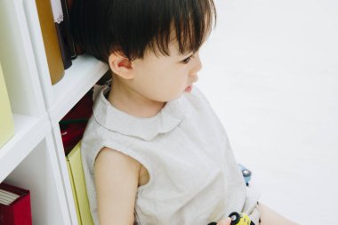 Yerde oturan Asyalı küçük çocuk..