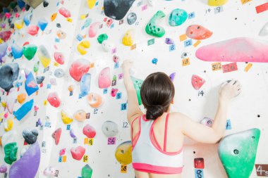 Güzel Japon kadın spor salonunda duvara tırmanıyor. 