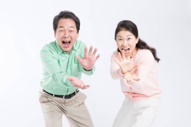 Asyalı yaşlı çift canavar çenesi hareketi yapıyor, stüdyo çekimi.
