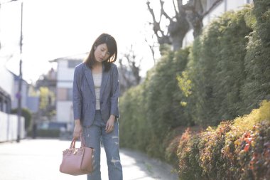 Asyalı üzgün kadın şehirde duran ceket giyiyor.