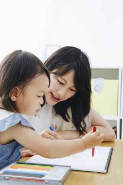 Annesiyle resim çizen tatlı Asyalı kız.