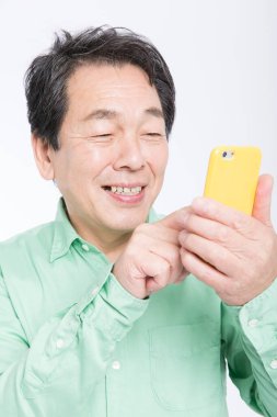 Beyaz arka planda izole edilmiş akıllı telefon kullanan üst düzey Asyalı adam 