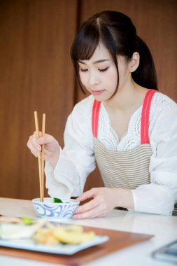 Güzel Asyalı kadın mutfakta yemek yapıyor.