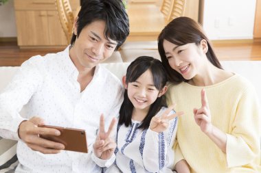 Aile kanepeye gülümseyip selfie çekiyor.