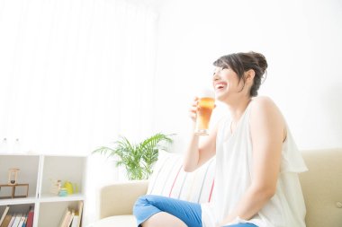 Genç Japon kadın elinde bira tutuyor.