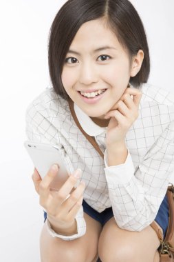 Genç Asyalı kadın akıllı telefon kullanıyor.