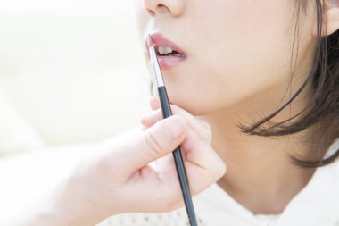 Güzel Asyalı genç kadın makyajını yaptırıyor.