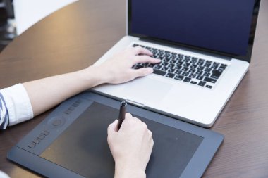 Young man using laptop while studying in modern cafe
