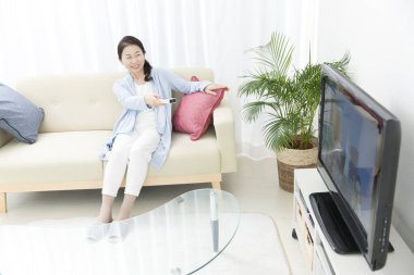 Asyalı kadın uzaktan kumanda kullanıyor 