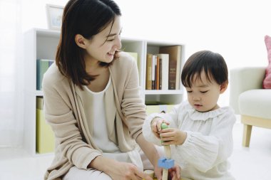 Evde annesiyle oynayan tatlı Asyalı kız.