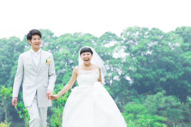 Parkta poz veren Asyalı gelin ve damat 