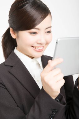 Tablet bilgisayarlı genç Asyalı kadın beyaz arka planda izole edilmiş. 