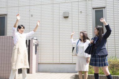 Asyalı bir adam karısına ve kızına veda ediyor.