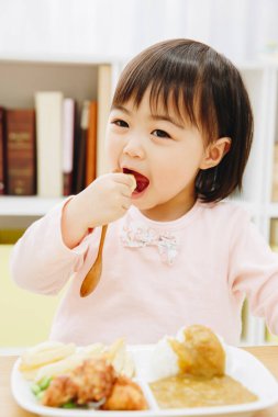 Güzel Asyalı kız evde Japon yemeği yiyor.