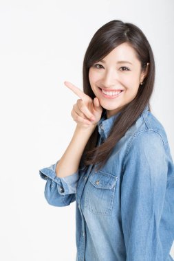 Asyalı kadının portresi izole edilmiş beyaz arkaplanı işaret ediyor.