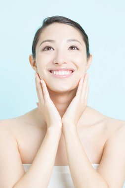 Güzel, genç Asyalı bir kadın. Temiz ciltli gülümsüyor. yüz tedavisi, kozmetoloji, spa ve sağlık