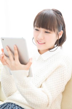 Güzel Japon kadın evde tablet kullanıyor.