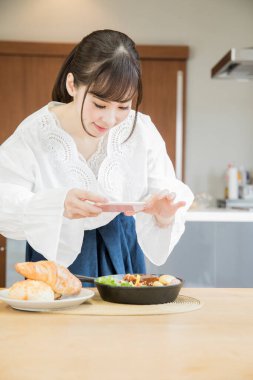 Kadın sebzeli pirinç kasesinin fotoğrafını çekiyor.