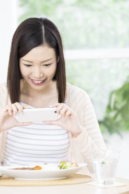 Yemek fotoğrafı çeken genç bir kadın. 