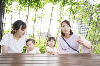 Parktaki küçük kızları olan Asyalı anneler.